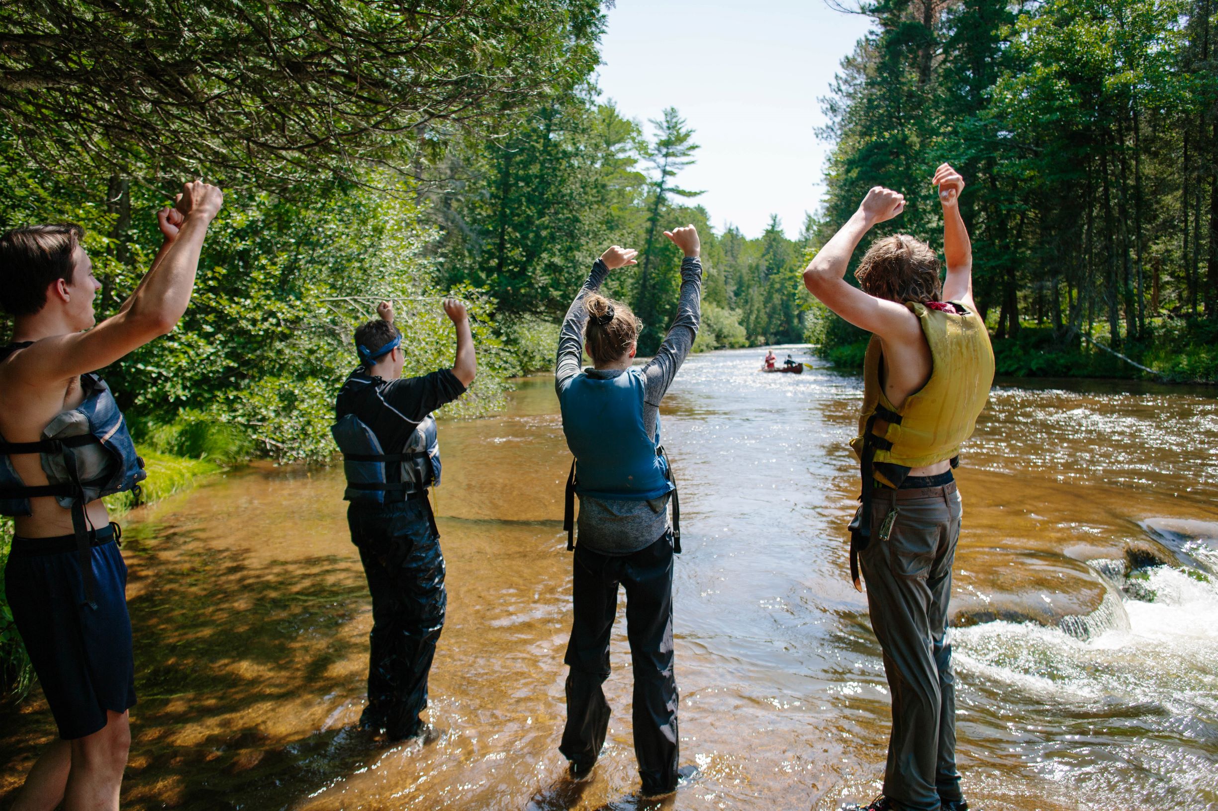 A team of women work together to pull a 35' Montreal Canoe onto shore in the Apostle Islands